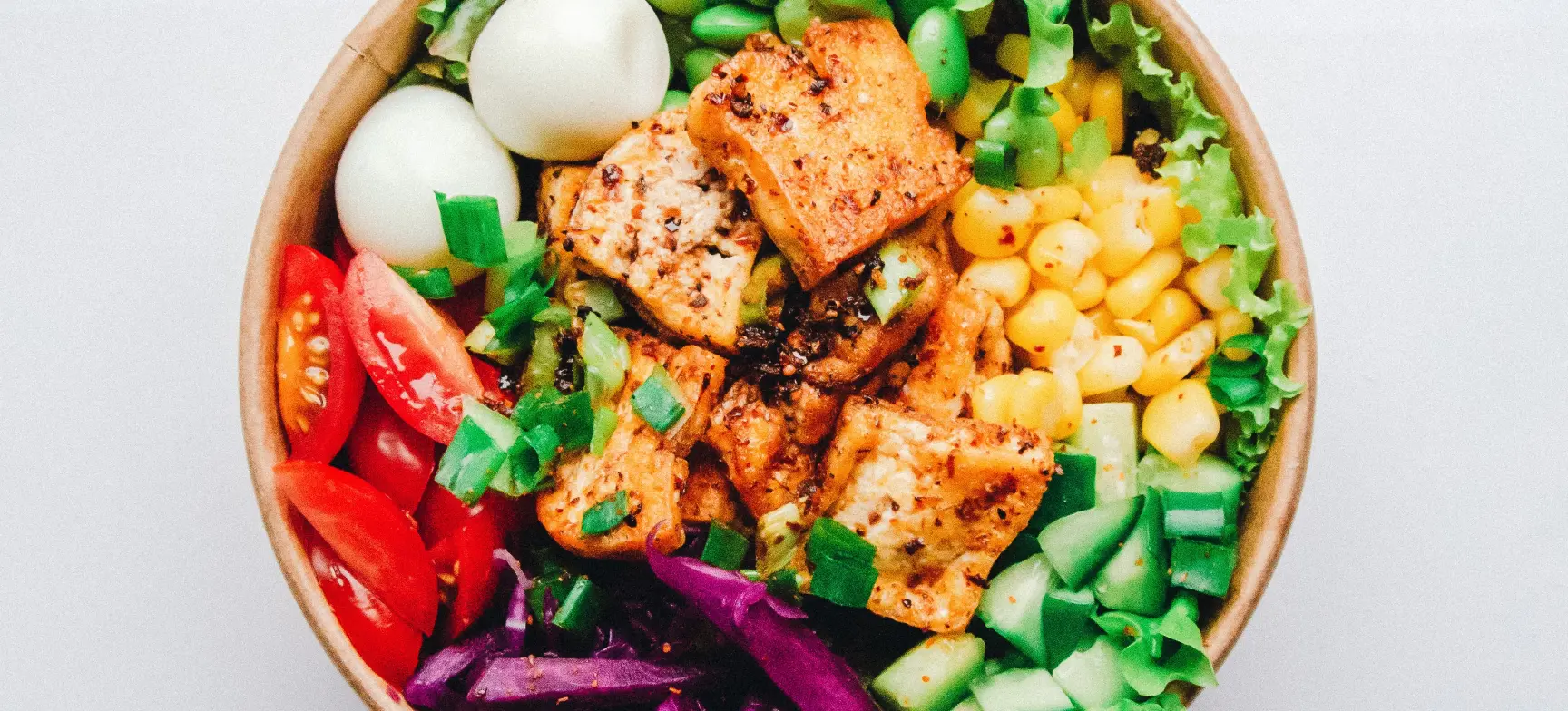 Colourfull pokebowl recipe with salmon, eggs, corn, cucomber, tomato and edamame beans