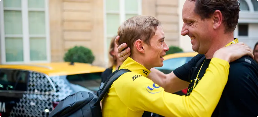 Merijn Zeeman hugging Jonas Vingegaard after winning 2022's Tour the France