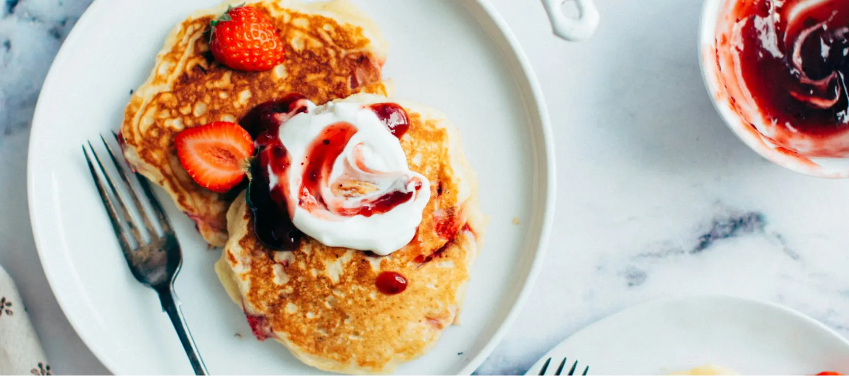 Pancakes with strawberries, jam and quark