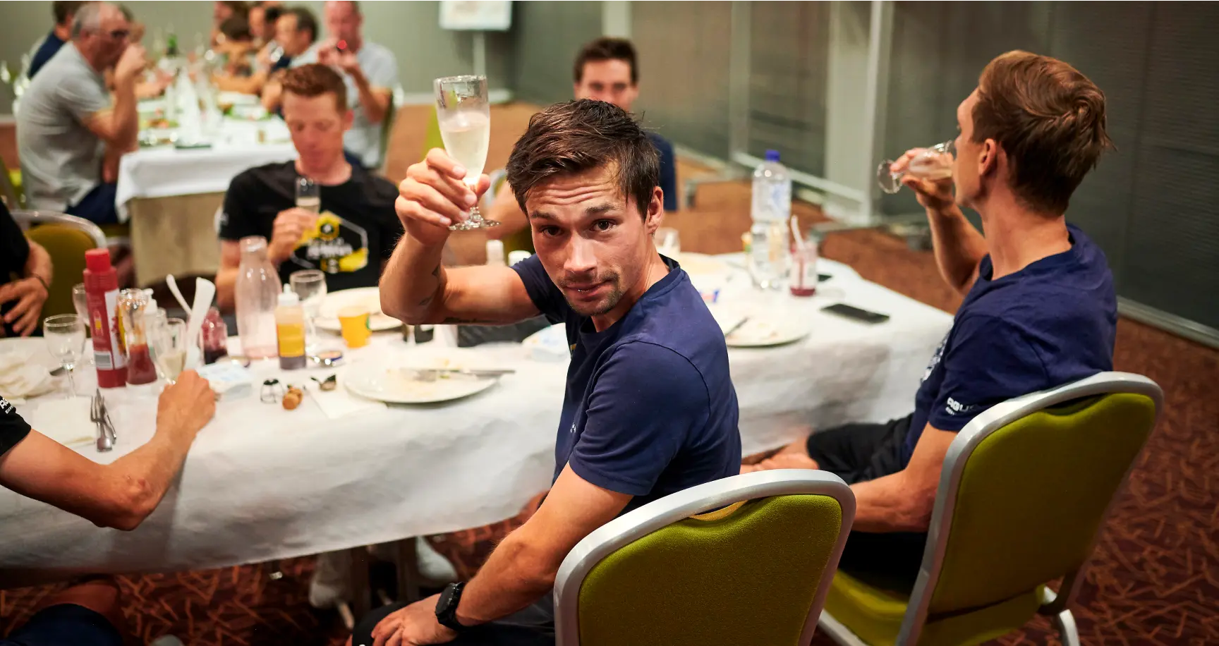 Primoz Roglic making a toast with a glass of champagne