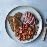 Steak with spicy tomato salad and toast